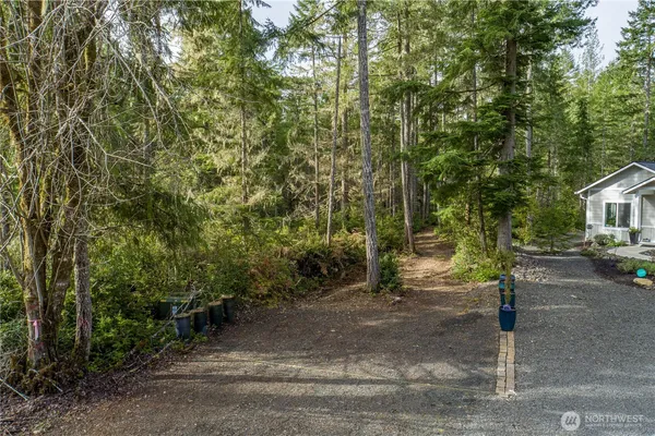a pathway of a house with cars parked on road