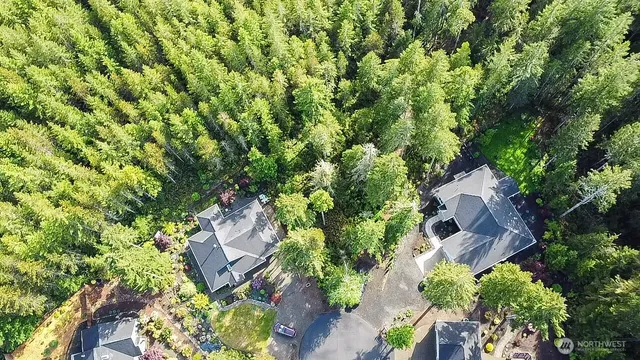 an aerial view of residential house with outdoor space and trees all around