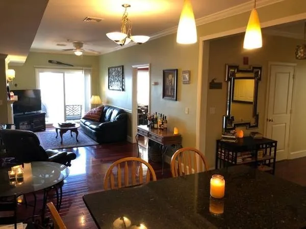 a living room with furniture a chandelier and a dining table