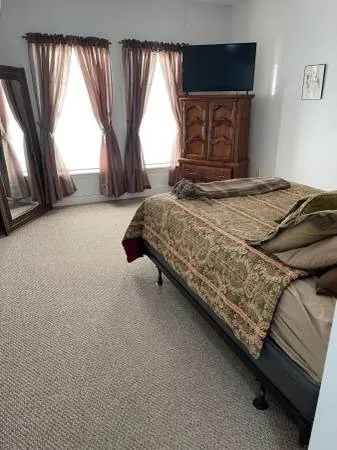 a bedroom with a bed next to a large window