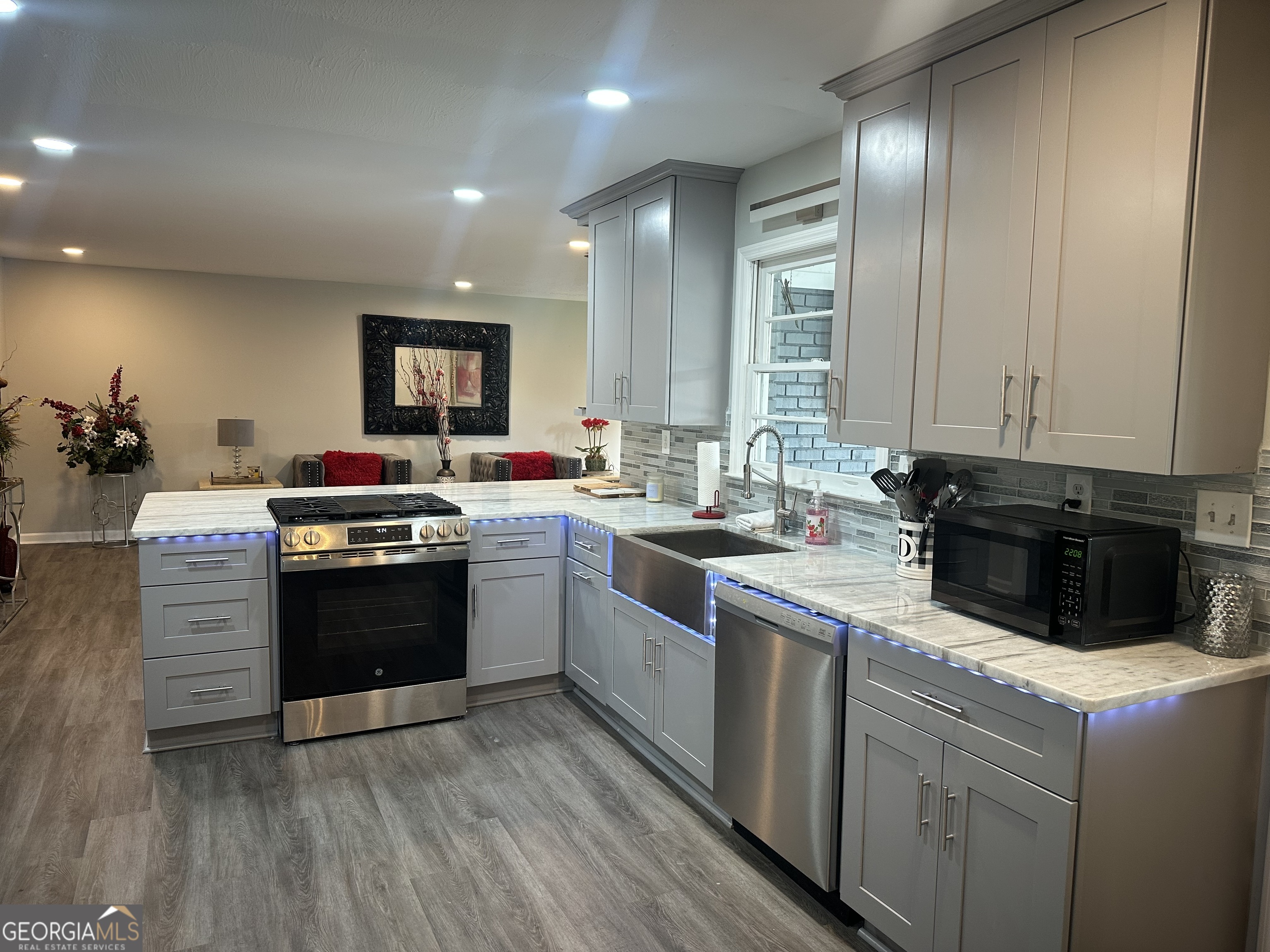 7383 Pleasant Hill Road Lithonia, GA 30058 - Photo 2 of 18 a kitchen with stainless steel appliances kitchen island granite countertop a stove a sink and a microwave