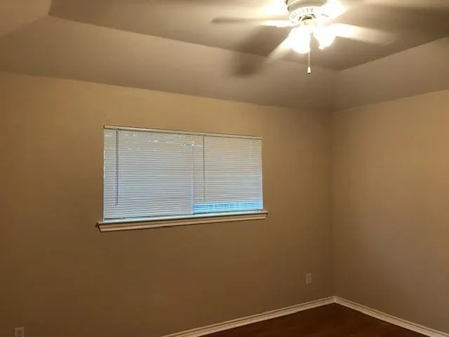 an empty room with a ceiling fan and a window
