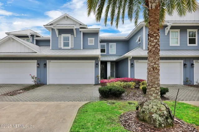 a front view of a house with a garden and plants