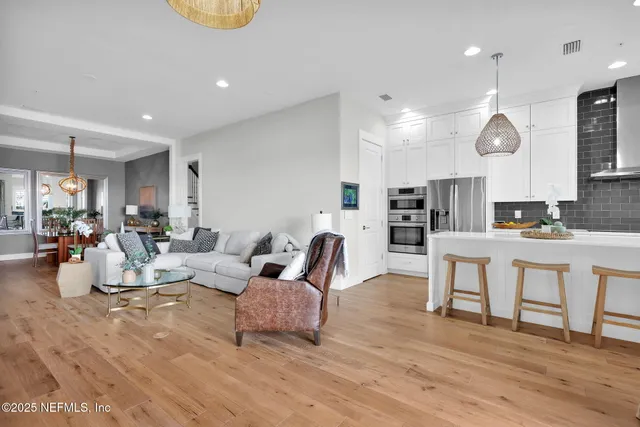 a living room kitchen with furniture and a wooden floor