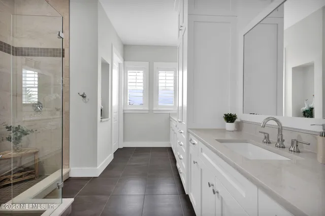 a bathroom with a double vanity sink a toilet and a shower