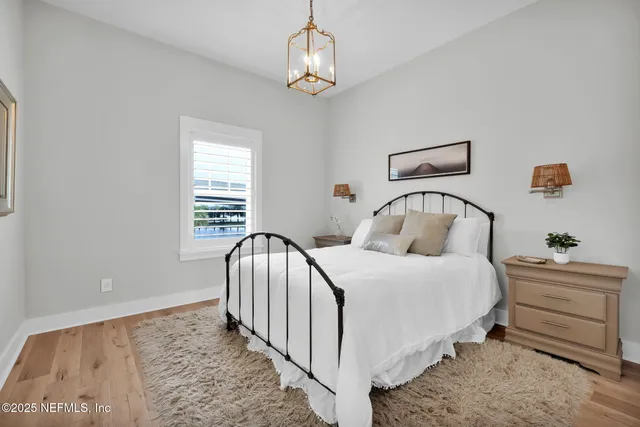 a bedroom with a bed and a chandelier
