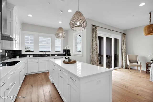 a large kitchen with kitchen island a large counter space a sink appliances and cabinets