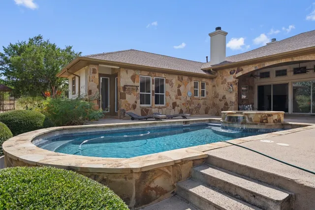 a view of house with yard outdoor seating and swimming pool