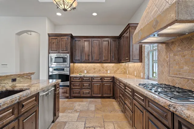 a kitchen with stainless steel appliances granite countertop a stove and a sink