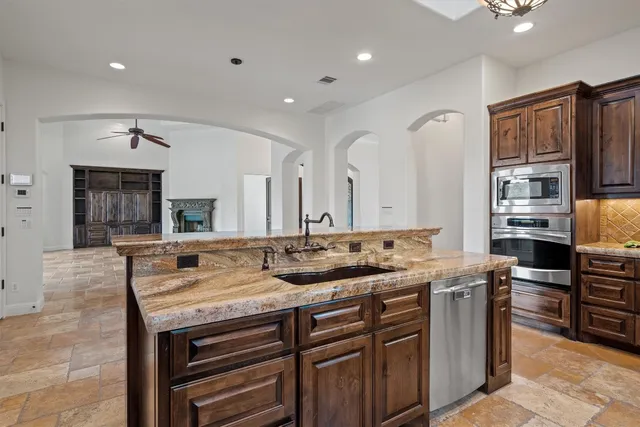 a kitchen with stainless steel appliances granite countertop a sink and cabinets