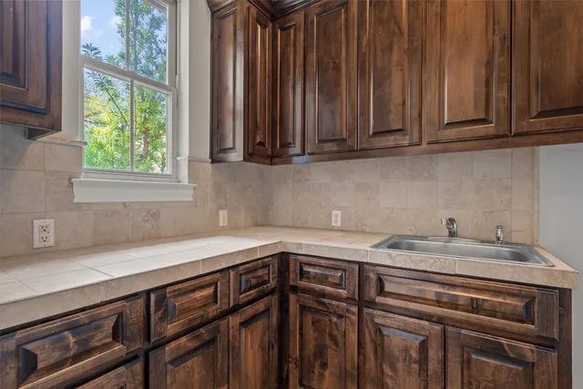 a kitchen with granite countertop a sink a stove and cabinets