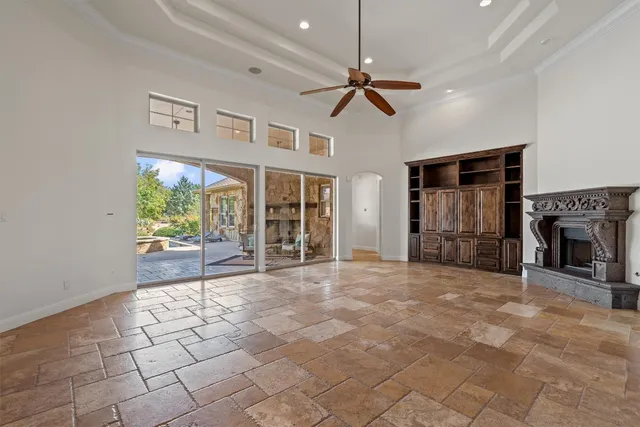 a view of an empty room with a fireplace and a window