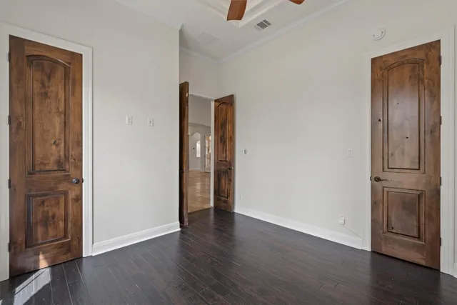 an empty room with wooden floor & closet and windows