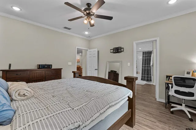 a bedroom with a large bed and a chandelier