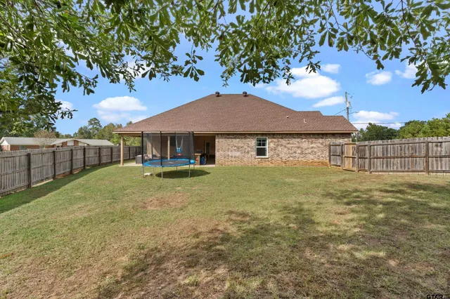 a view of a house with backyard and tree