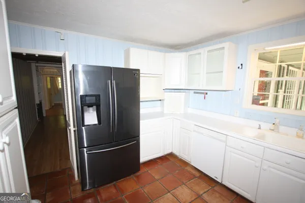 a kitchen with a refrigerator a sink and cabinets