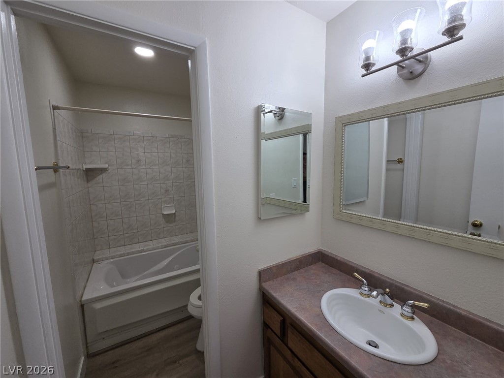 3317 Racquet Street Las Vegas, NV 89121 - Photo 11 of 23 This bathroom features practical finishes, including a sink, vanity, and a tub with tiled surround.