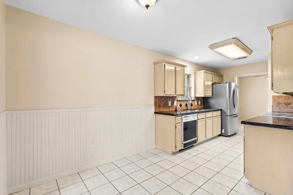 a kitchen with granite countertop white cabinets and stainless steel appliances