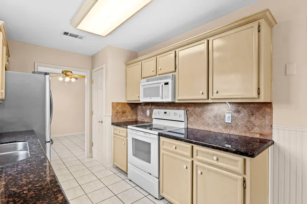 a kitchen with white cabinets and white appliances
