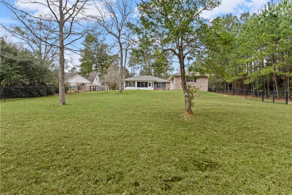 a view of a house with a big yard and large trees