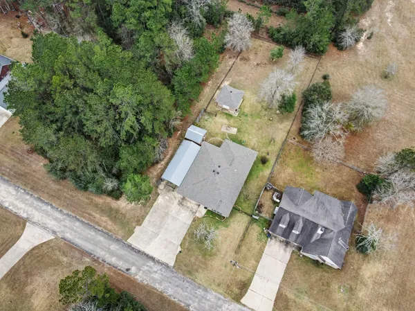 an aerial view of a house with a yard and lake view