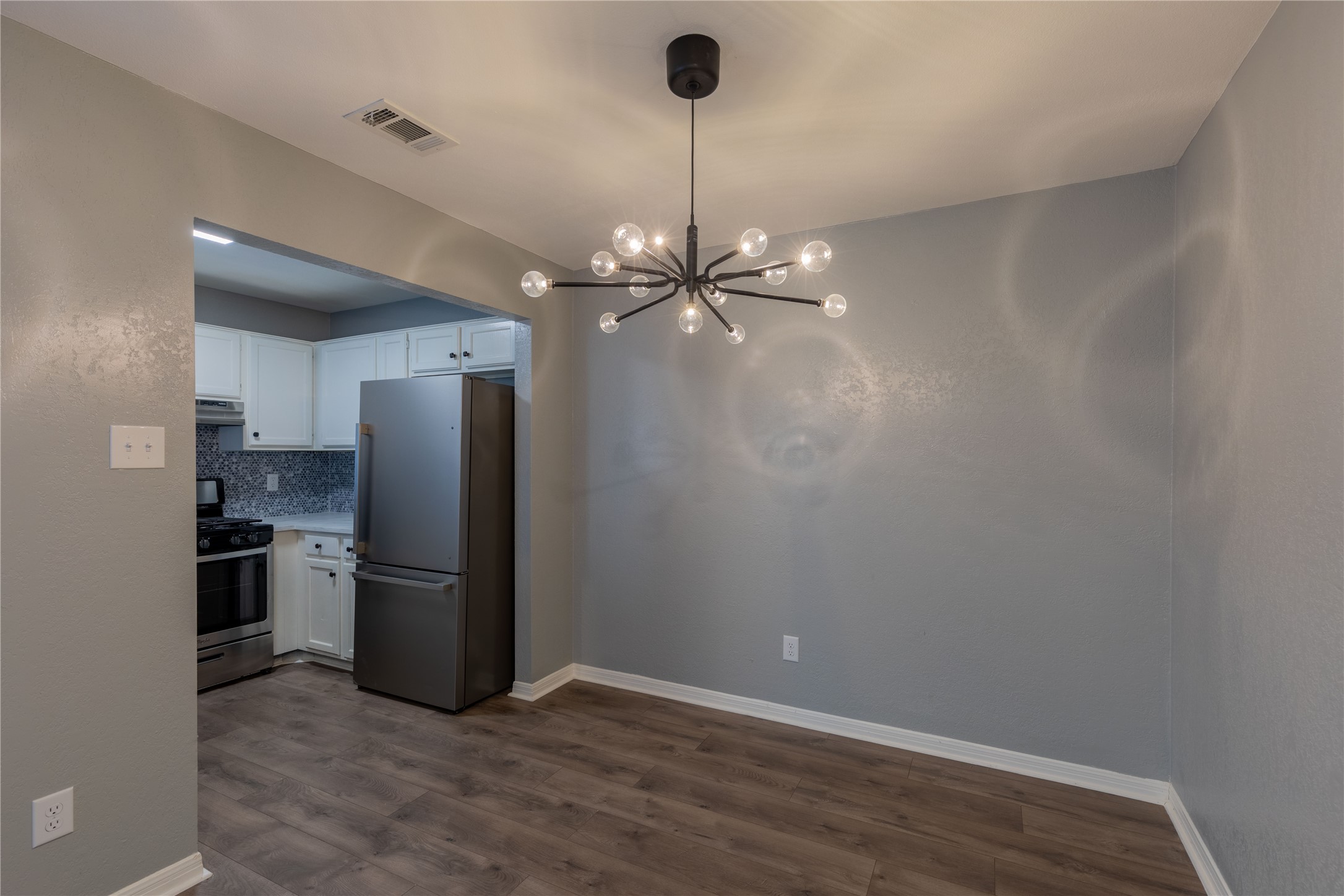 319 Rawhide Loop Round Rock, TX 78681 - Photo 6 of 28 Unfurnished dining area featuring a chandelier and dark wood finished floors