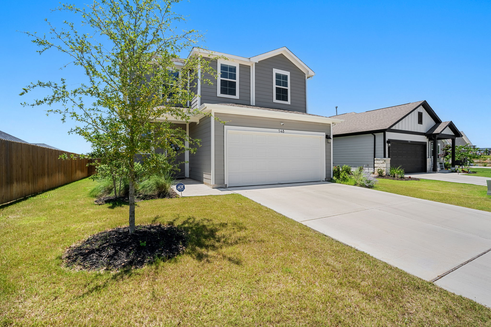 148 Hidalgo Lane Elgin, TX 78621 - Photo 36 of 38 A well-maintained lawn and concrete driveway lead to this charming two-story residence.