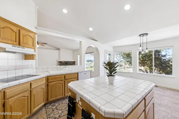 a kitchen with stainless steel appliances granite countertop a sink a stove a dining table and chairs