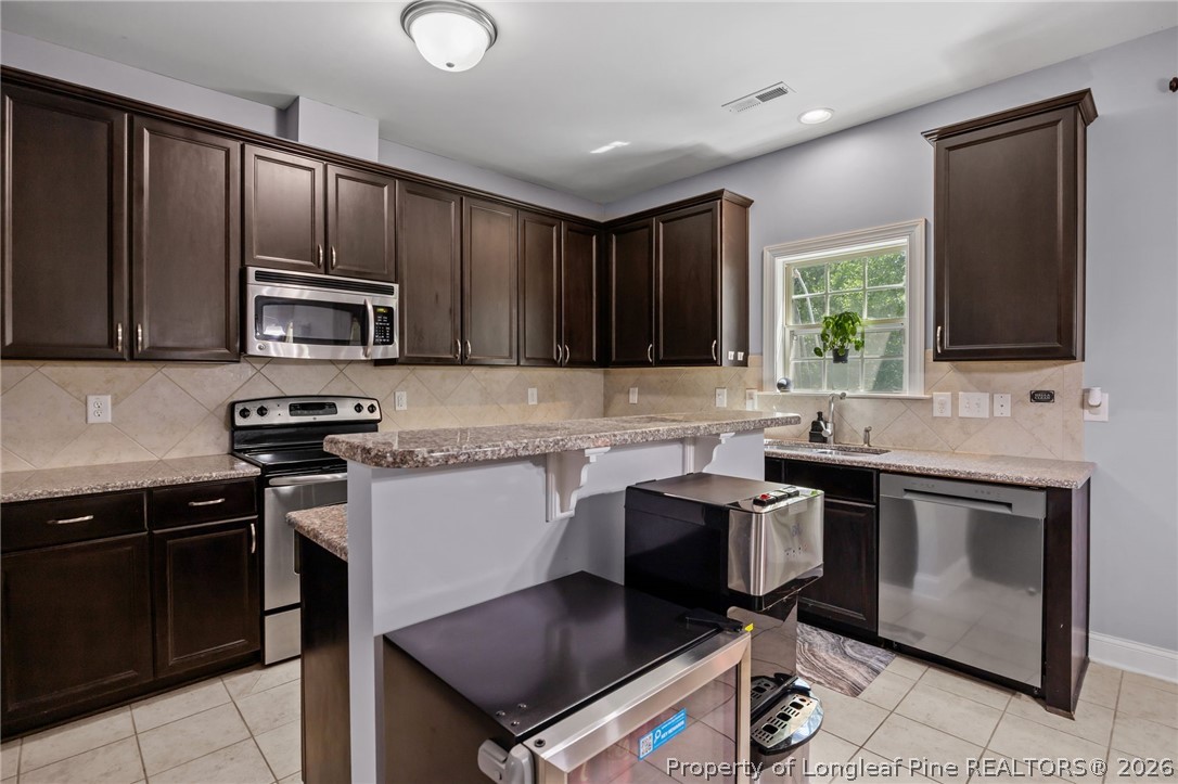 64 Cromwell Circle Cameron, NC 28326 - Photo 2 of 50 a kitchen with stainless steel appliances granite countertop a stove microwave and sink