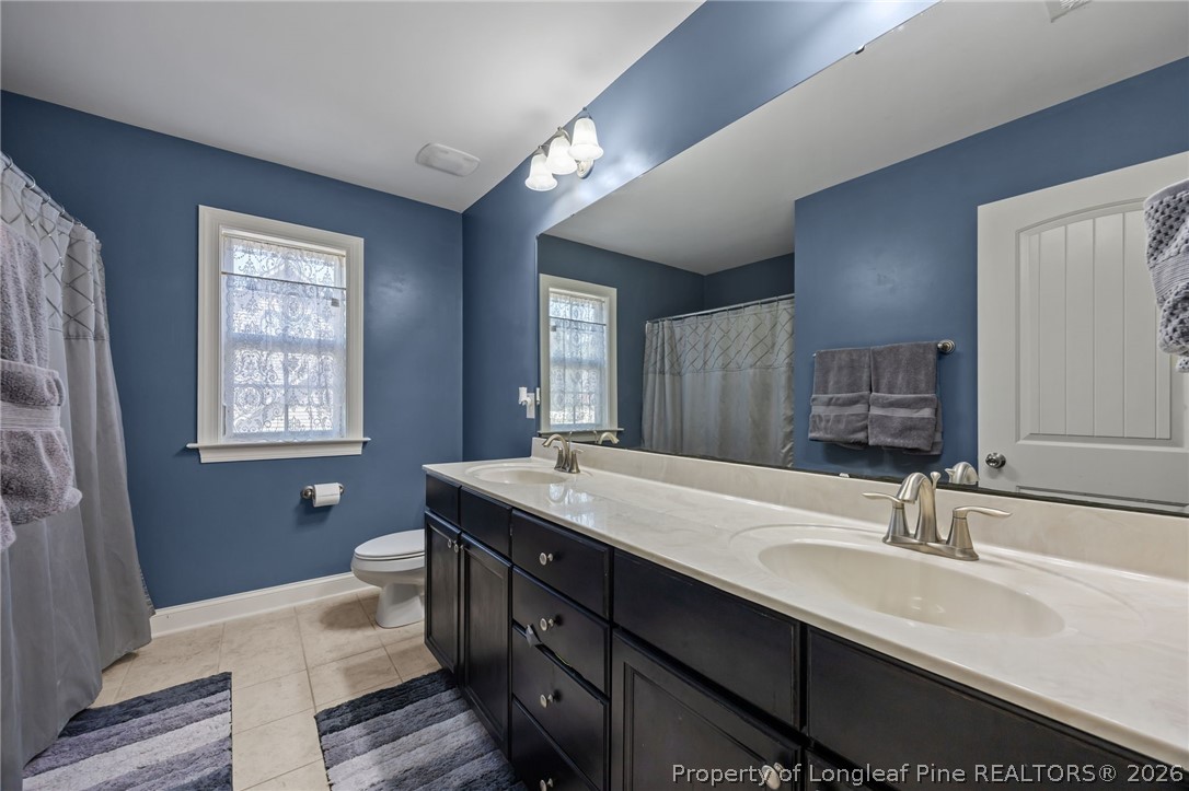 64 Cromwell Circle Cameron, NC 28326 - Photo 32 of 50 a bathroom with a double vanity sink a large mirror and a bathtub