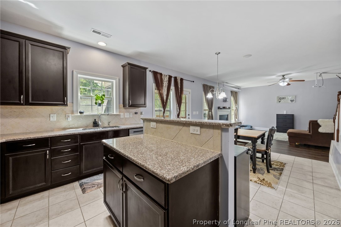 64 Cromwell Circle Cameron, NC 28326 - Photo 6 of 50 a kitchen with a stove a kitchen island a dining table and chairs