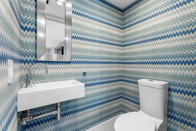 a bathroom with a toilet a sink and mirror