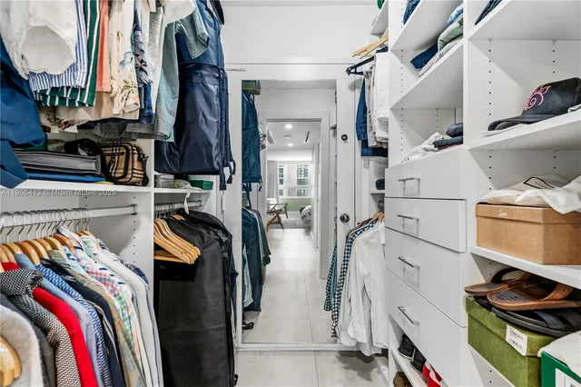 a view of walk in closet with clothes and shoes