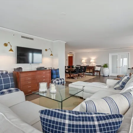 a living room with furniture a flat screen tv and kitchen view