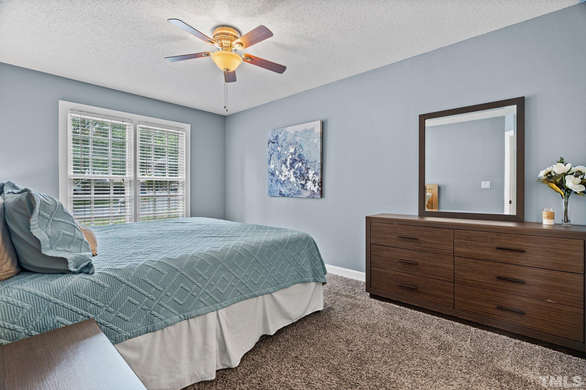 7128 Tullamore Drive Raleigh, NC 27613 - Photo 17 of 37 a bedroom with a bed and a chandelier