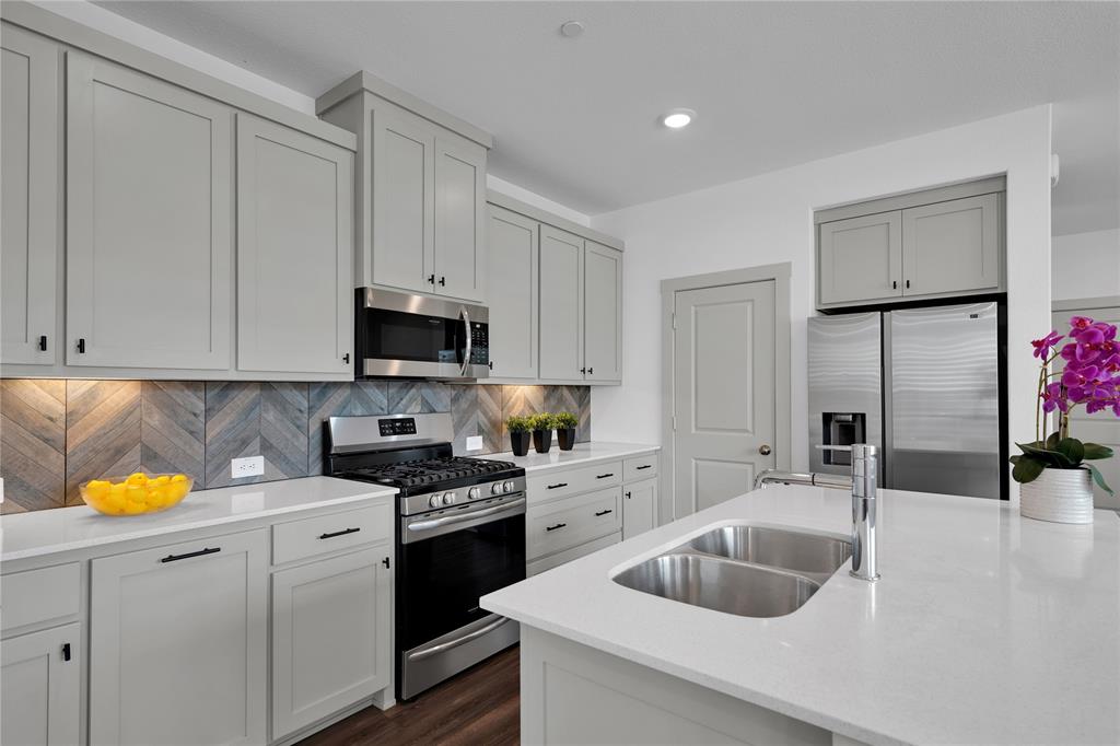 673 Vista Oaks Road Lewisville, TX 75067 - Photo 1 of 1 a kitchen with white cabinets and appliances