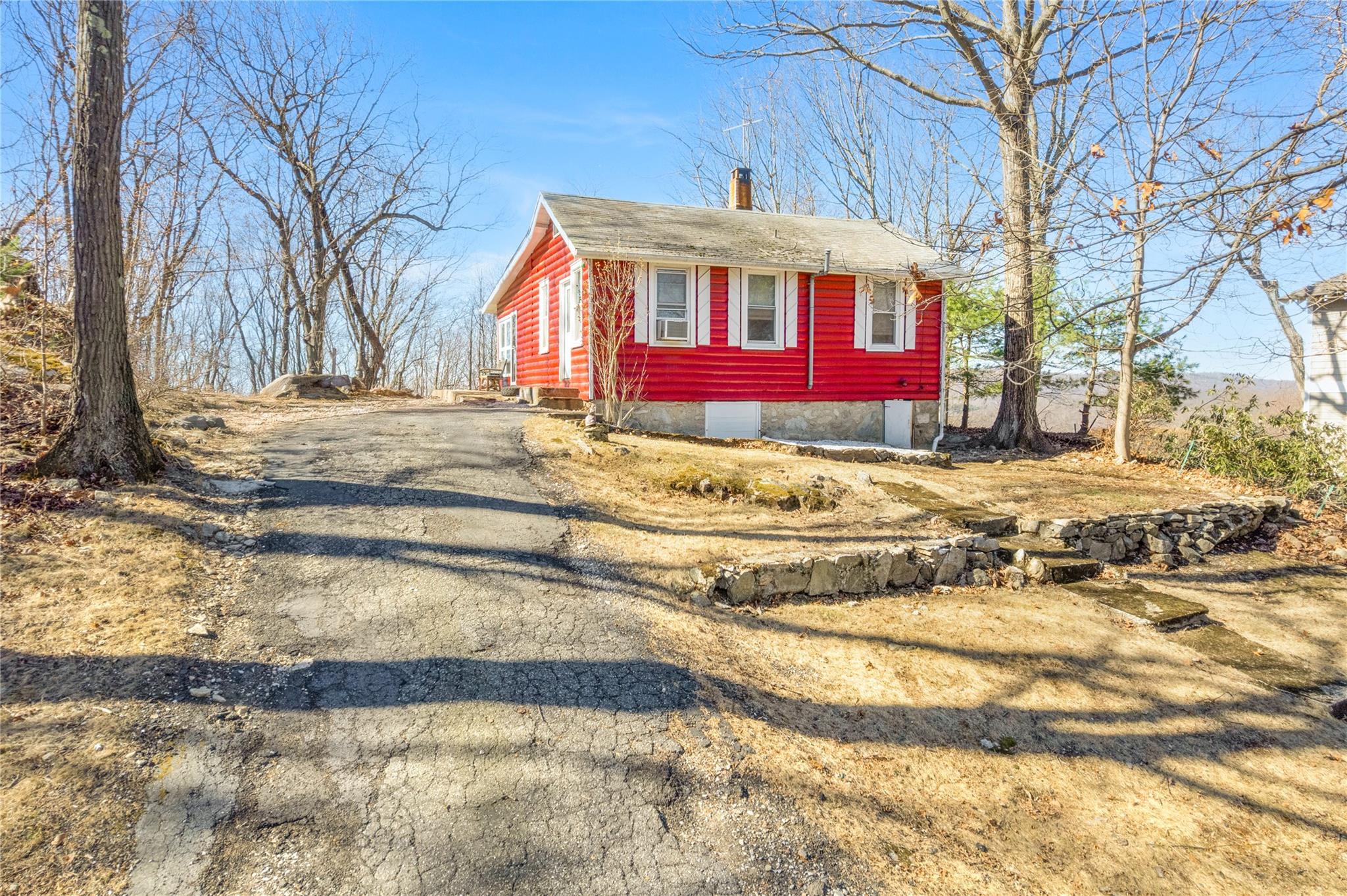 View of front of home featuring a chimney and driveway