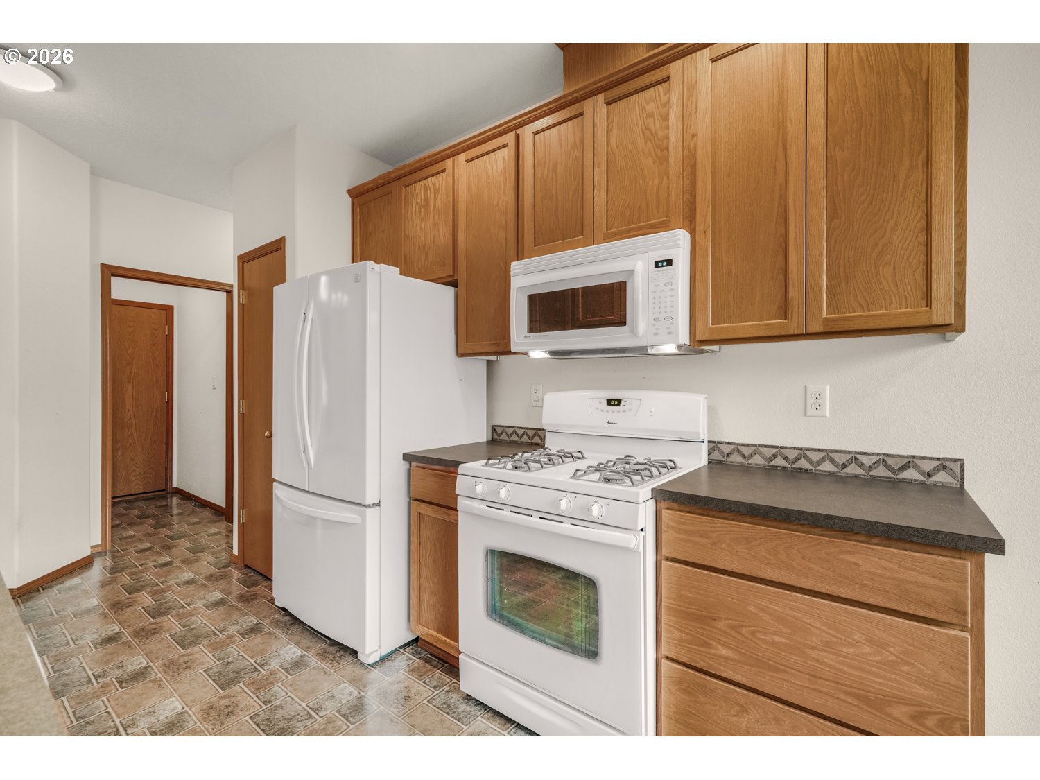 52234 Southeast Tyler Street Scappoose, OR 97056 - Photo 12 of 30 a kitchen with a stove microwave and refrigerator