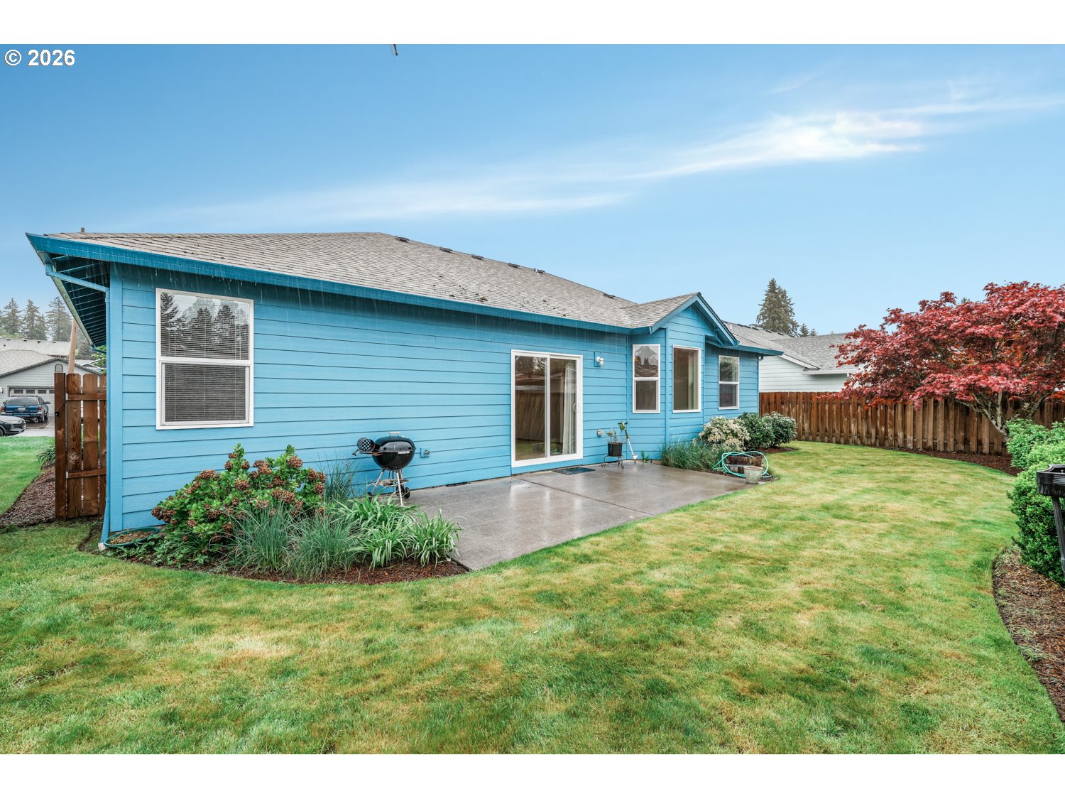 52234 Southeast Tyler Street Scappoose, OR 97056 - Photo 26 of 30 a backyard of a house with potted plants and a large tree