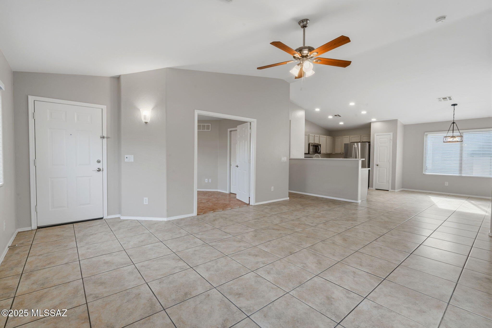 8244 South Lost Mountain Road Tucson, AZ 85747 - Photo 4 of 41 a view of a livingroom with a ceiling fan and kitchen space