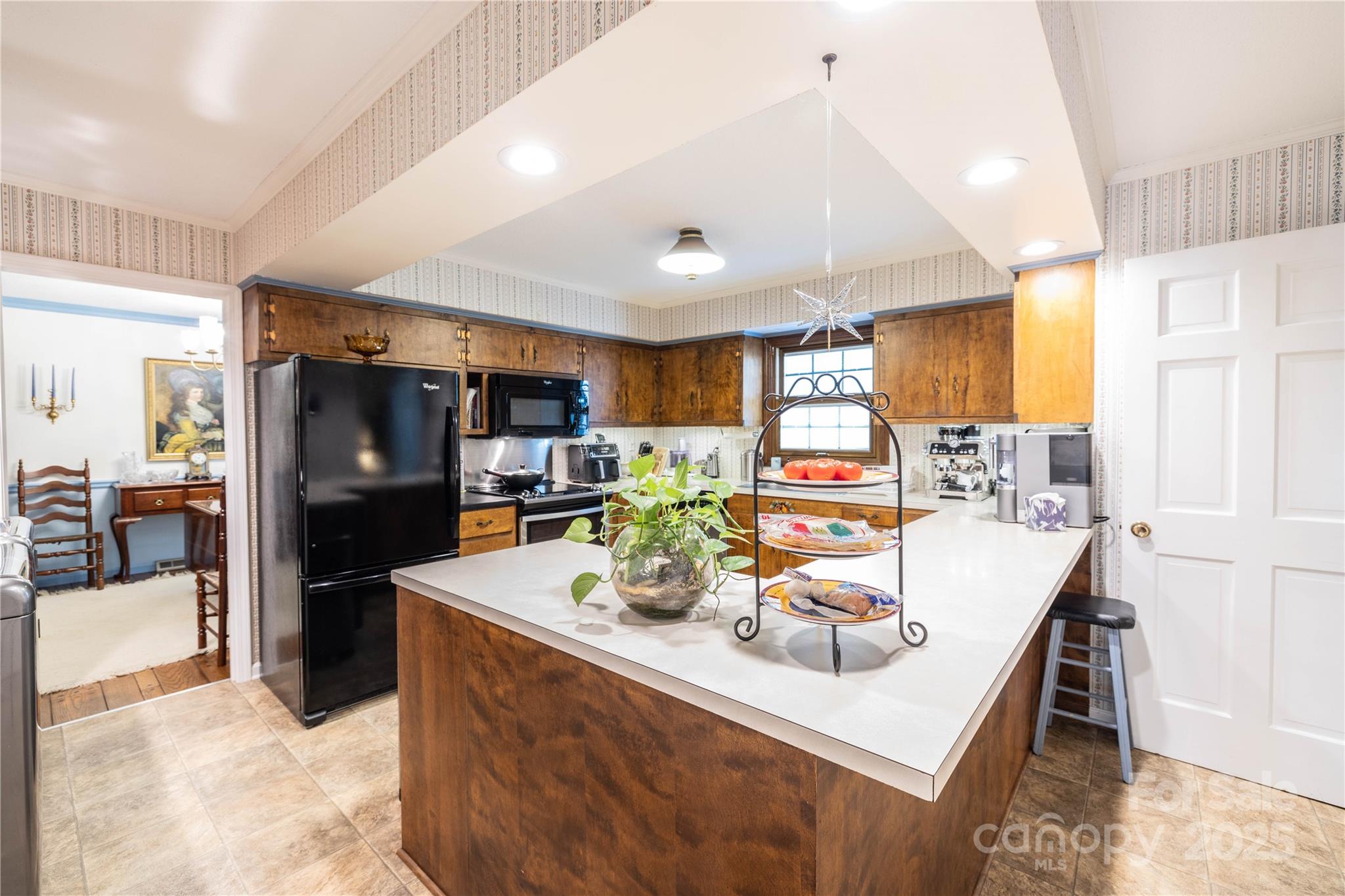 42765 Caudle Road Richfield, NC 28137 - Photo 24 of 37 a room with stainless steel appliances kitchen island granite countertop a table chairs and a refrigerator