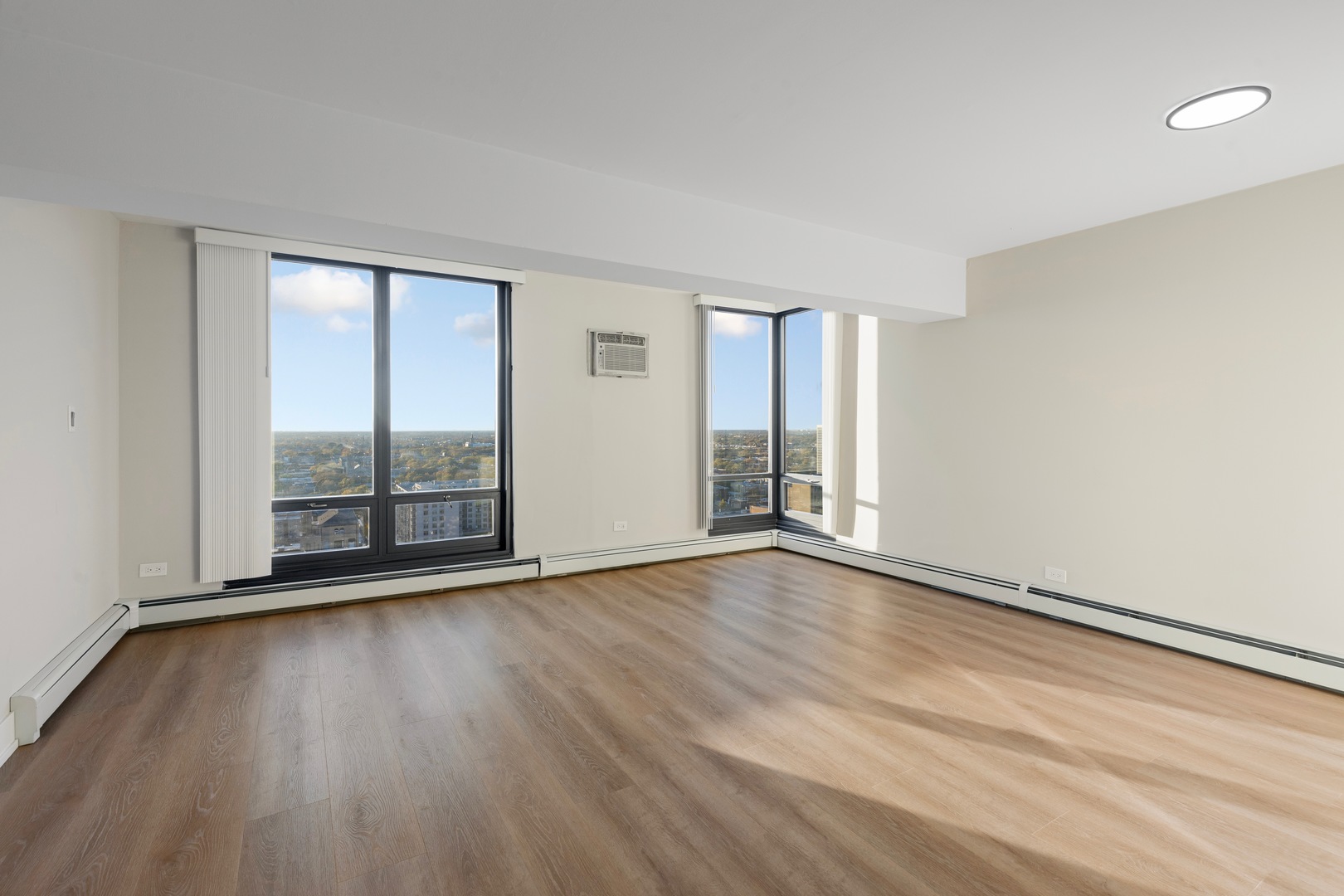 6166 North Sheridan Road, Unit 24B Chicago, IL 60660 - Photo 2 of 17 an empty room with wooden floor and windows