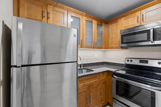 a white refrigerator freezer and a stove sitting inside of a kitchen