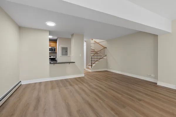 a view of empty room with wooden floor