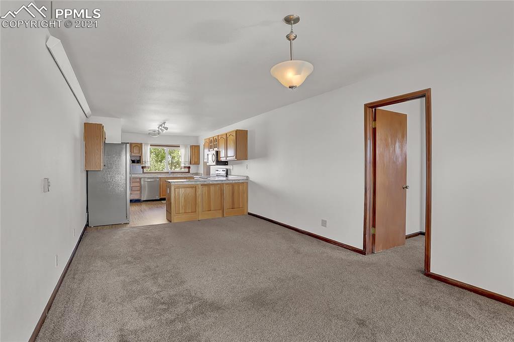 8155 North Log Road Peyton, CO 80831 - Photo 13 of 29 a view of a kitchen with a refrigerator a sink and dishwasher cabinets
