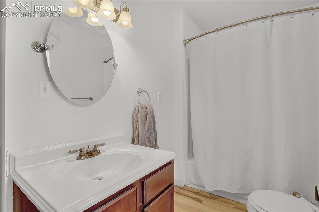8155 North Log Road Peyton, CO 80831 - Photo 16 of 29 a bathroom with a sink vanity mirror and toilet