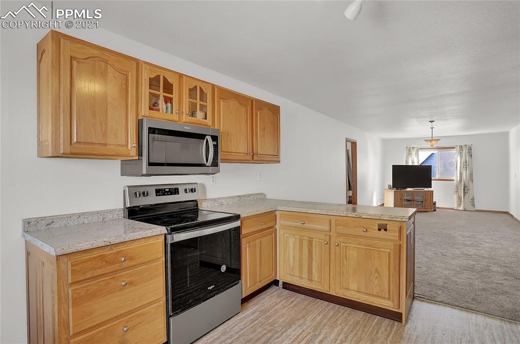 8155 North Log Road Peyton, CO 80831 - Photo 8 of 29 a kitchen with granite countertop cabinets stainless steel appliances and wooden floor