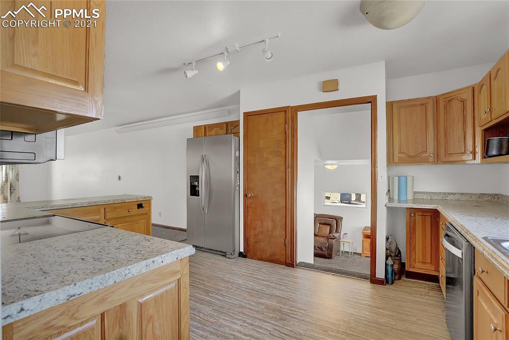 8155 North Log Road Peyton, CO 80831 - Photo 9 of 29 a kitchen with stainless steel appliances granite countertop a sink and a refrigerator