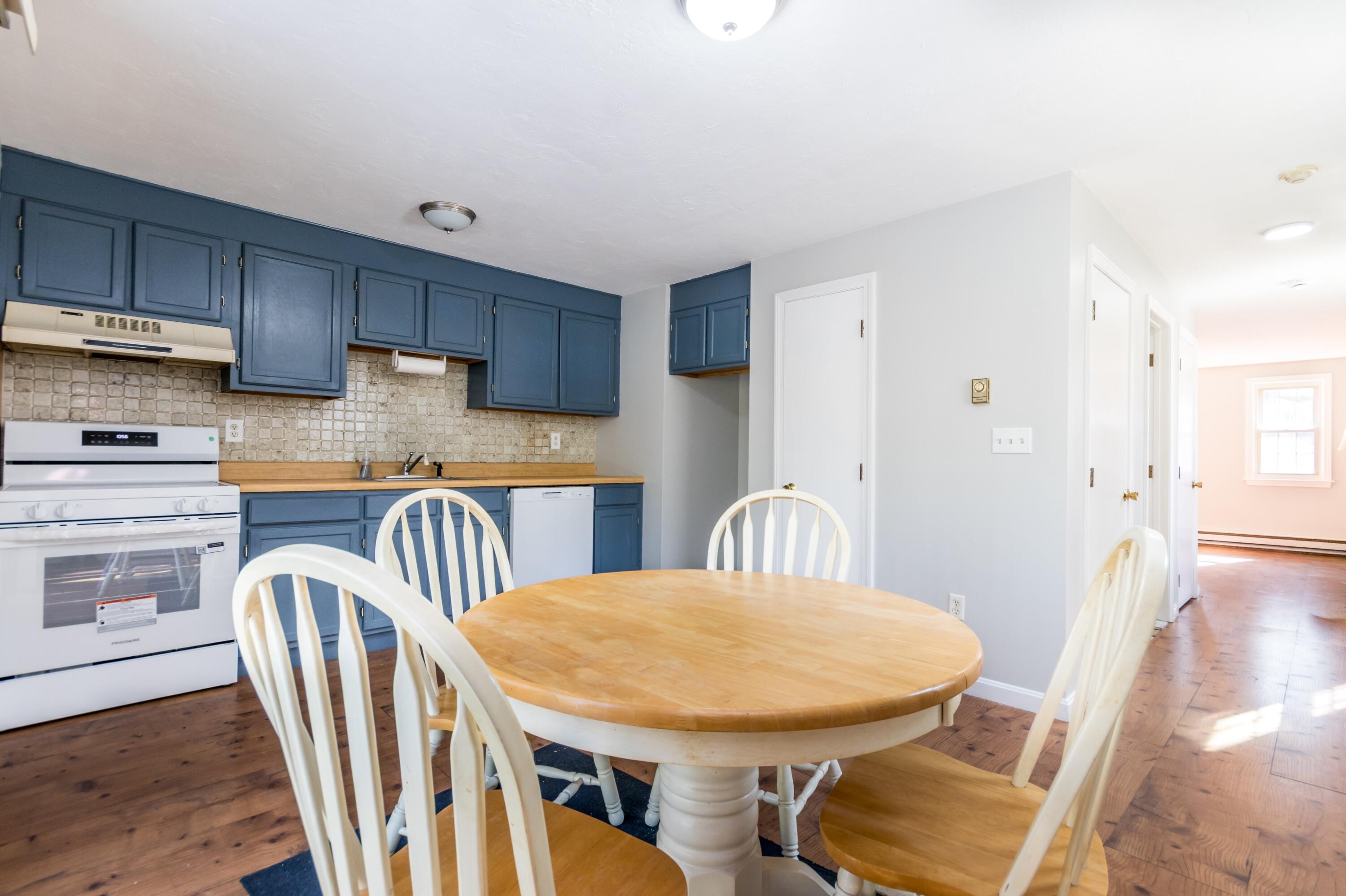 300 Falmouth Road, Unit 16A Mashpee, MA 02649 - Photo 13 of 25 a kitchen with stainless steel appliances a dining table chairs and wooden floor