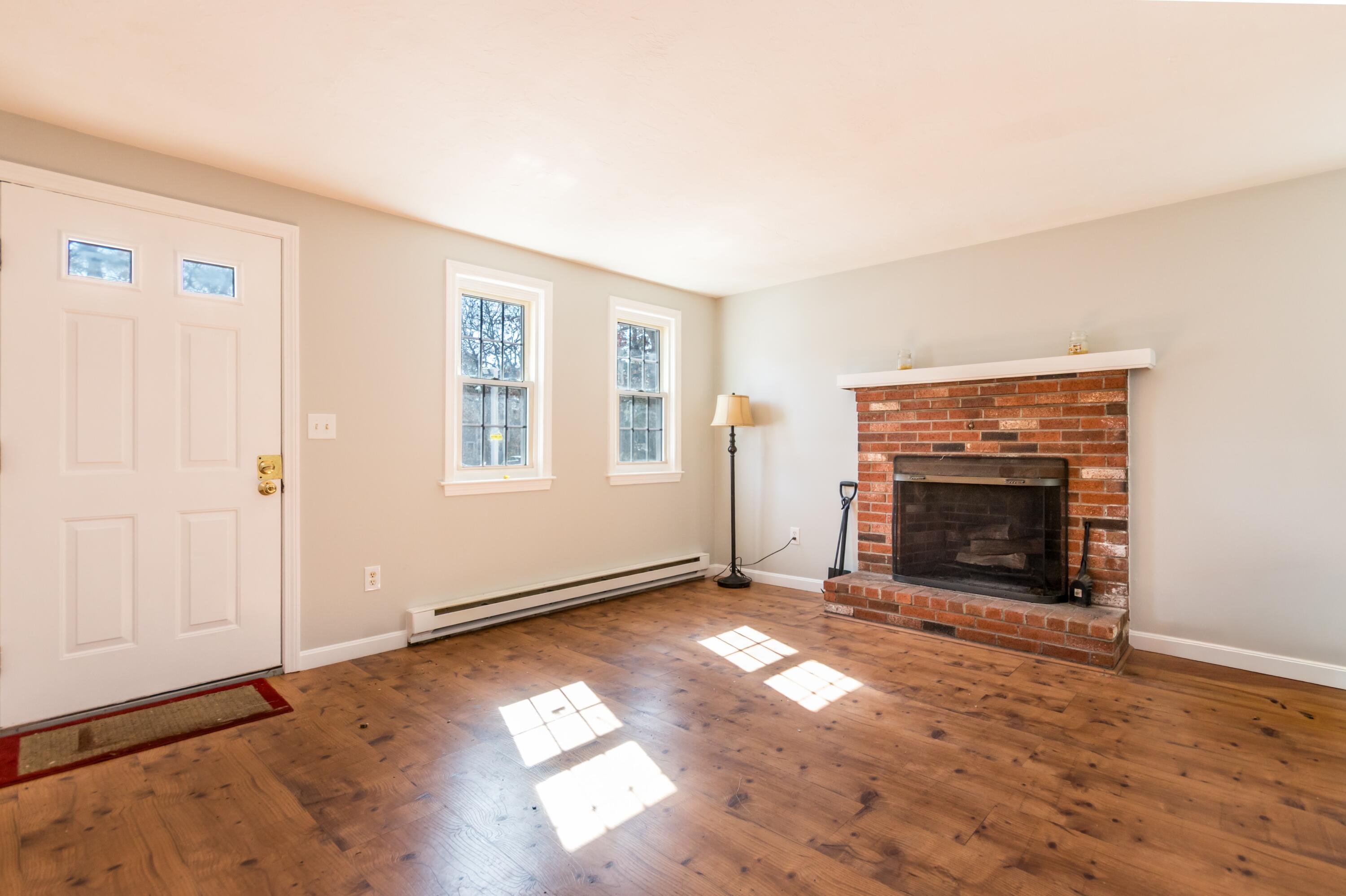 300 Falmouth Road, Unit 16A Mashpee, MA 02649 - Photo 5 of 25 an empty room with windows fireplace and wooden floor